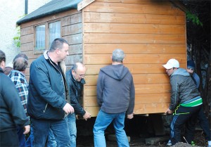 Image of men lifting the shed